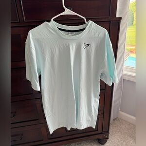 Size Medium, men’s shirt from Gymshark. It is a teal colored t shirt